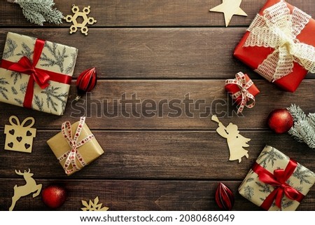 Vintage Christmas wooden background with gift boxes, wooden decorations, red baubles and fir branches. New Year postcard template, Christmas banner design.