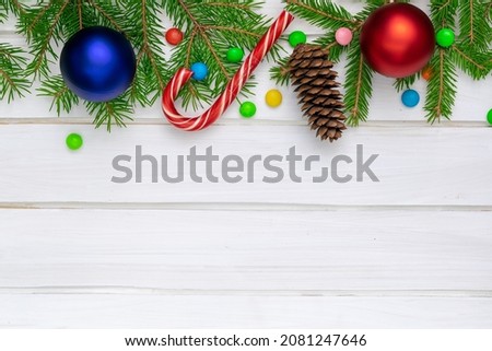 Christmas back,ground, green fir branches, red and blue, yellow, ball, candies, cone, white boards