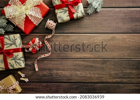 Christmas background with gift boxes, fir branches, vintage ribbon on wooden plank table. Top view, flat lay. Xmas or New Year greeting card design.