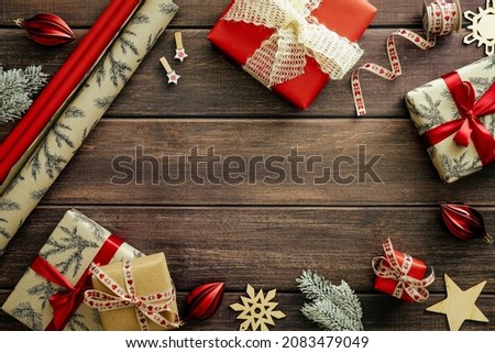 Vintage Christmas background with gift boxes, Xmas decorations, wrapping paper on wooden table. Flat lay, top view, copy space. Christmas card design, New Year postcard template.