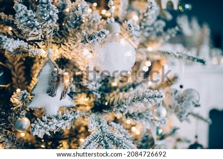 Beautiful snowy Christmas tree against blue background with beautiful ornaments for the holidays. 