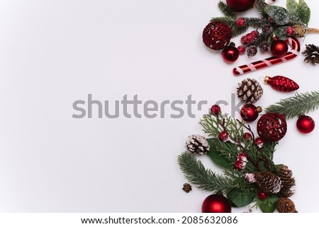Christmas photo of branches of a tree with red toys and balls on a white background