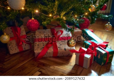 Wrapped christmas gifts under the tree on a Christmas evening