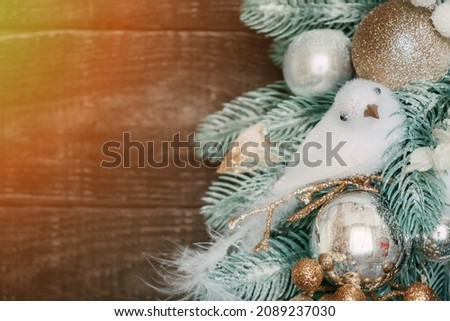 Part of a Christmas wreath with a sitting white bird on a dark wooden background. Christmas decoration.