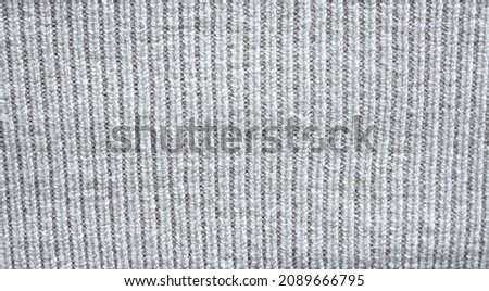 Acrylic textile texture background of plaid: white woolen fabric, sheep wool clothing, soft warm clothes. Knitted tissue of pullover and sweater