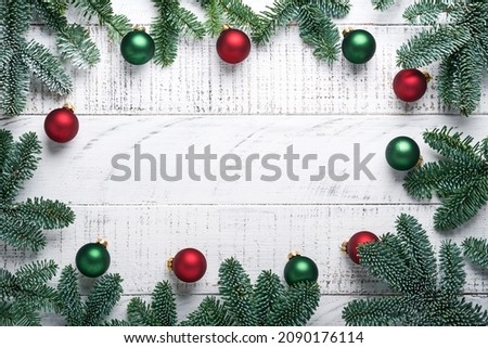 Christmas Decoration. Holiday Decorations with gold baubles, cones, bells, fir branches and present on the old white wooden board background. Border design. Top view. Mock up. 