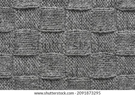 Gray knitted wool pattern texture background. Handmade Knitwear. Checkered textured background, top view