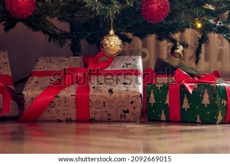 Close-up of presents spread over the floor under the christmas tree on a beautiful holiday at home. Christmas, home, presents