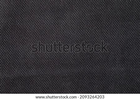 The texture of the fabric. Dark grey jacquard close-up. Soft expensive fabric for furniture, curtains, pillows and car upholstery. Background. A place to copy.