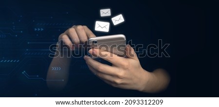 E-mail and social media. Hands using smartphone with new messages icon. Business and marketing concept, black background