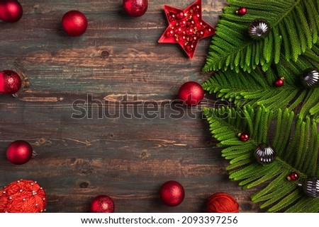 Christmas pine leaf with red bauble decoration on wooden table