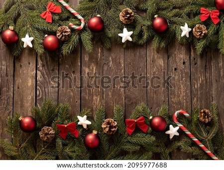 Creative idea for Christmas decoration on wooden background using traditional winter holiday ornaments and evergreen branches, bringing happiness into your home concept