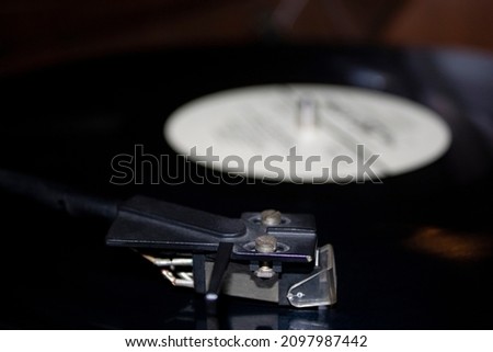 While playing the record, Black platter. Modern vinyl record player with disc on black background, closeup.