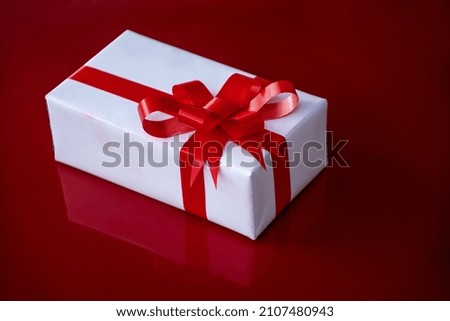 white gift with red ribbon

