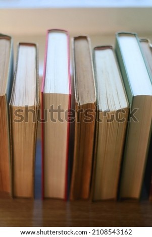 Bunch of vintage hardcover books on wooden background. Selective focus.