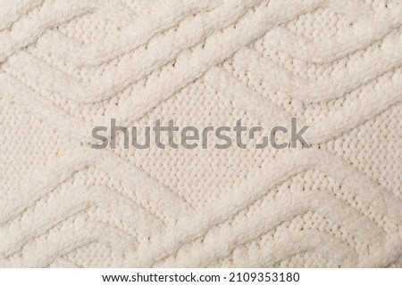 Knitted woolen sweater as background, closeup.