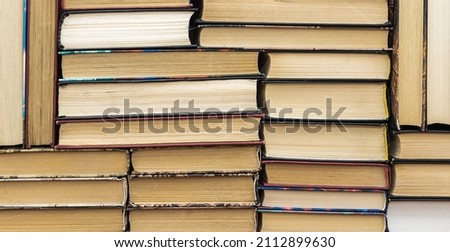 Education concept represented by a stack of books on a table in a library.