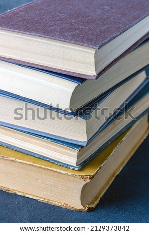 stack of books on a blue background, close-up