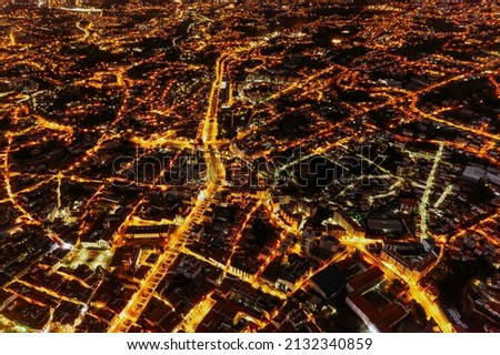 Majestic drone view of cityscape with bright illuminated streets and roads at night