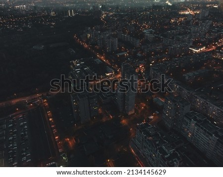 Aerial night city streets with lights illumination top flight in eastern Europe, Ukraine. Multistory buildings scenic dark contrast view. Industrial, urban moody background