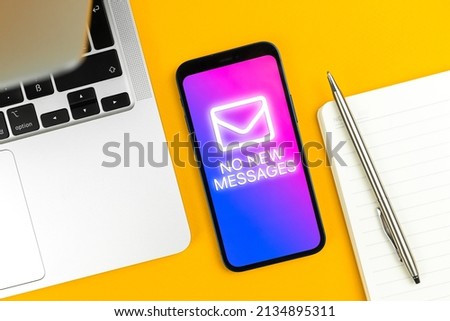 Waiting for a new message concept, business email background. Smartphone screen with no new messages notification, business workplace wooden table with laptop, top view