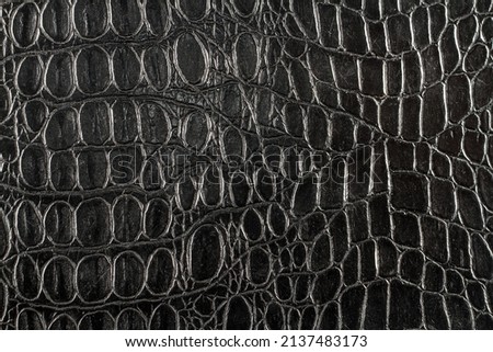 Texture of artificial crocodile skin. Black background texture of the skin.