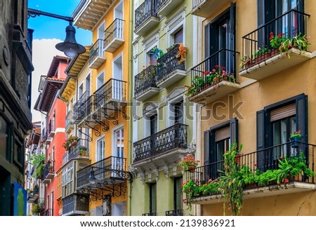 Colorful house facades and ornate metal balconies with flowers in the old town or Casco Viejo in Pamplona, Spain famous for running of the bulls