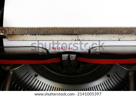 The German word Weltkrieg written in red on an old mechanical typewriter German Text: world war