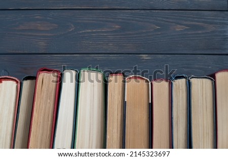 A stack of books on a gray wooden background. the concept of reading books on paper.