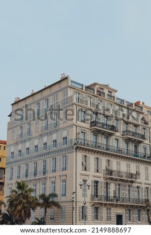 Residential building with the windows painted on a side wall in Nice, France, against the blue sky.