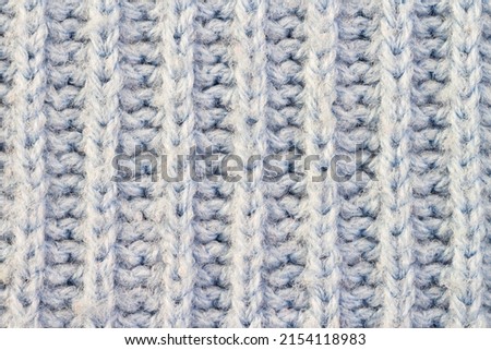 Knitted light woolen blue pattern with stripes braided surface macro