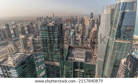 Panorama showing Dubai Marina and JLT with JBR district at morning. Ttraffic on highway between skyscrapers aerial timelapse. Modern towers and construction site. Yachts floating in harbor