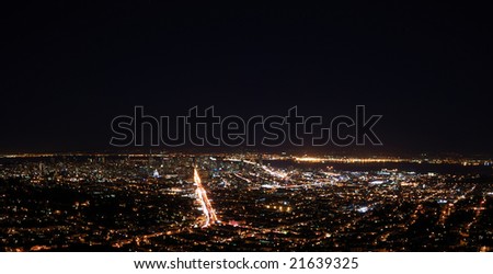 San Francisco at Night Panorama showing the Bay Bridge and downtown with Market Street as the brightest and Oakland across the Bay