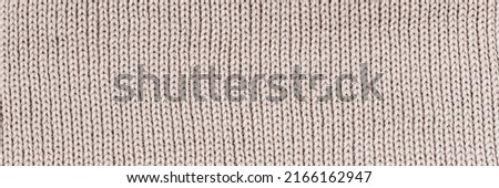 Fashion background. Beige knitted fabric backdrop. Jersey scarf knit backdrop. Warm winter sweater. Banner.