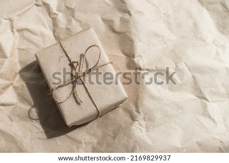 Gift box in craft packaging with a rope bow. Eco-friendly gifts. Place for text. Natural eco-friendly gifts. Minimalism. Gift minimalism.