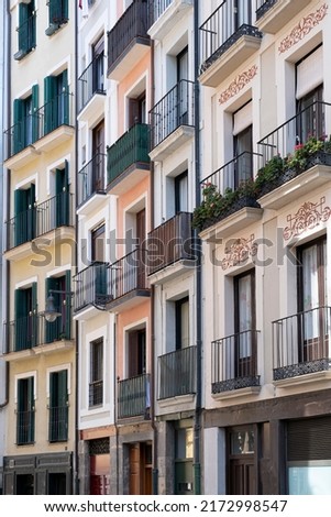 facades of several restored old houses on a narrow street full of small balconies, historic downtown Pamplona, Navarre, Spain