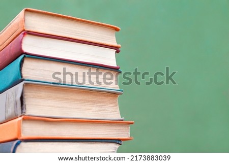 a stack of colorful books close-up on a blackboard background