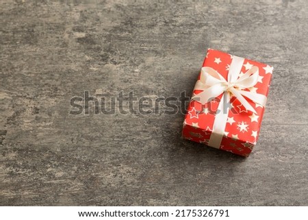 Wrapped christmas or other holiday handmade present in paper with colored ribbon. Present box, decoration of gift on table, top view with copy space.