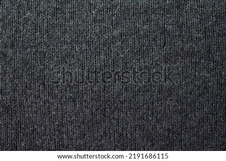 Knitted pattern closeup. Soft sweater texture, detailed yarn background. Natural woolen fabric, a fragment of a jersey pullover. Trendy backdrop for print, web design.