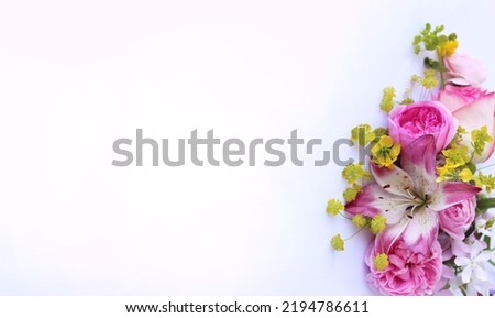 Delicate pink lilies and roses on a white background. Festive flower arrangement. Background for a greeting card.