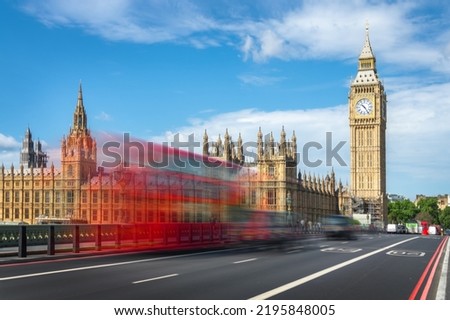 Red double decker bus with motion blur on Westminster bridge, Big Ben in the background, in London, UK