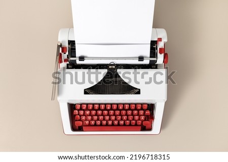 Top view of a retro and colorful typewriter with blank white paper. Creative writing process concept