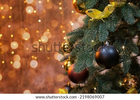 Decorated Christmas tree on blurred background. Close up of balls on christmas tree. Mocap place for text. Bokeh garlands in the background. Christmas concept. Bokeh of christmas garland lights