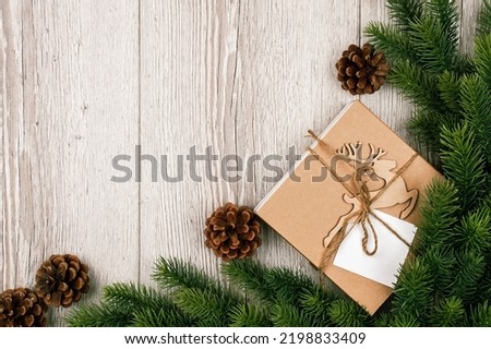 New Years gift box with deer, branch christmas tree on a wooden background. Banner with space for text. rustic background. Vintage planked wood with Christmas tree branches.Flat lay. Top view
