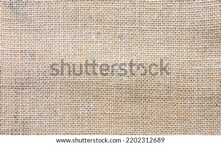 Retro natural linen bag burlap beige texture background.
Brown hessian jute pattern backdrop.