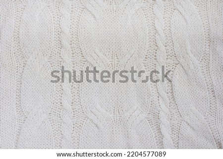 patterned knitted fabric in the Irish style. The texture of knitted fabric knitted with knitting needles