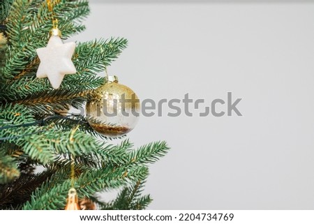 Part of Christmas tree with ball,star, Christmas lights garlands on white background. Copy space.
