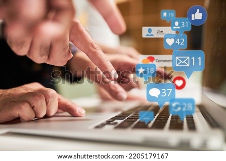 Finger typing on keyboard on laptop computer with many news icons as social media concept