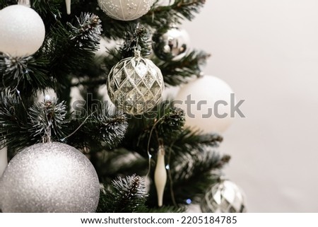Fancy decorations on a green Christmas tree: balls, candies, pine cones. Close up photo of decorated fir tree.