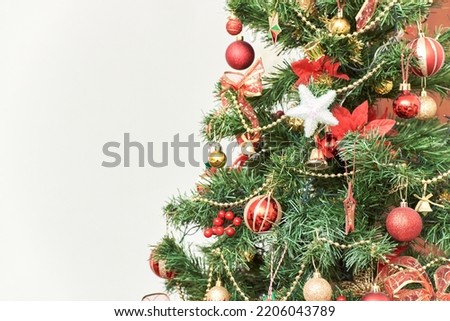 Home Christmas tree with ornaments in traditional colors, red, green and gold. Composition with copy space.